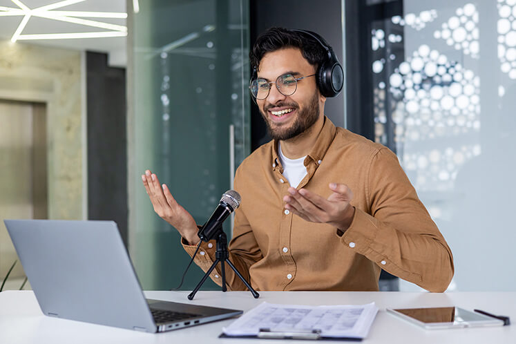 Man sitting in front of a laptop recording a webinar